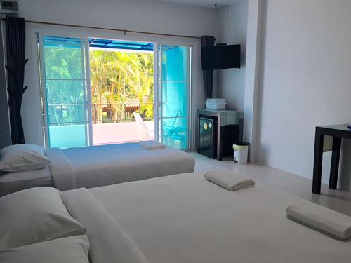two beds in a room with a window at Ban Krut Resort in Ban Krut
