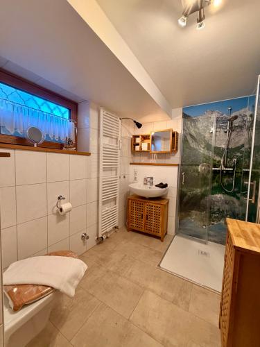 a bathroom with a shower and a toilet and a sink at Ferienwohnung Bergpanorama Schönau in Schönau am Königssee