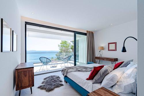 a bedroom with a bed and a view of the ocean at Luxury Seafront Villa Miracul Korcula with Pool in Blato