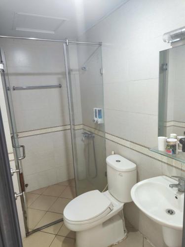 a bathroom with a shower and a toilet and a sink at okaeri hotel in Hanoi
