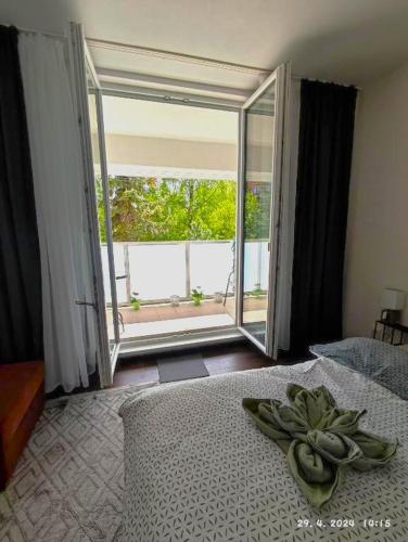 a bedroom with a bed and a large window at Apartmán M&K WEST in Poprad