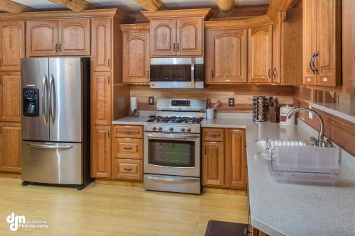 a kitchen with wooden cabinets and stainless steel appliances at Alaska Knotty Pine B&B in Palmer