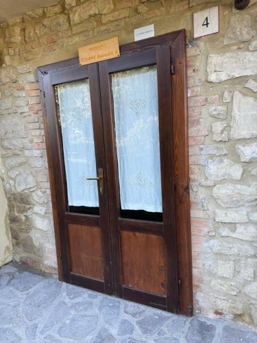 a wooden door in a stone wall with a sign above it at Guesthouse Nicol 2 in Collelungo