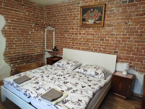 a bed in a room with a brick wall at Rodinný dom Cavern - Rajec, 7 km od Rajeckých Teplíc in Rajec