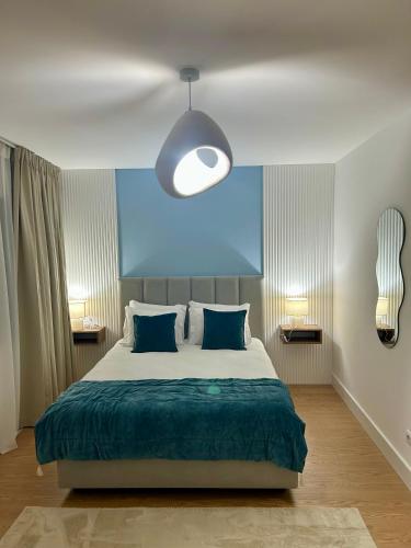 a bedroom with a large bed and a blue wall at Aquae Flaviae Urban Stay - Duplex in Chaves