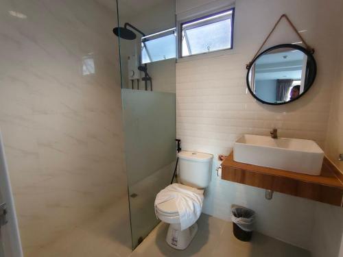 a bathroom with a toilet and a sink and a mirror at Chiang Mai Waroros Boutique Hotel in Chiang Mai