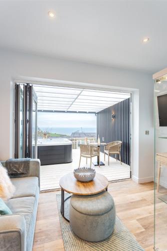a living room with a couch and a table at North Devon Resort One bedroom sea view hot tub Residence in Ilfracombe