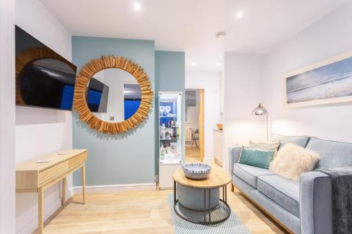a living room with a couch and a mirror at North Devon Resort One bedroom sea view hot tub Residence in Ilfracombe