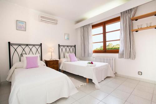 ein Schlafzimmer mit zwei Betten und einem Fenster in der Unterkunft Villa Gotmar in Port de Pollença