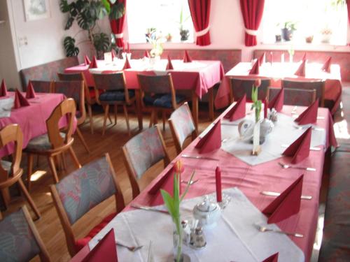 a dining room with tables and chairs with pink tablecloths at Gasthaus Zehrermühle in Schönberg
