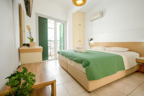 a bedroom with a large bed with a green blanket at 4YOU STUDIOS in Larnaca
