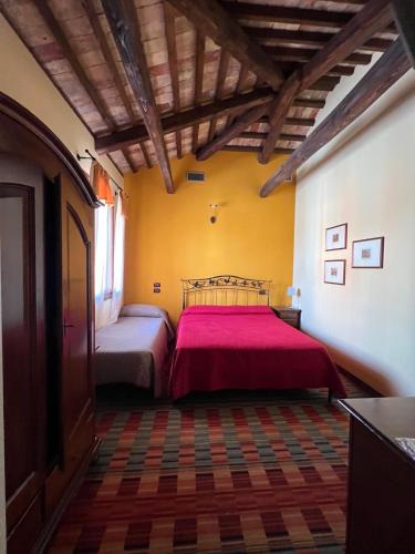 a bedroom with a bed with a red blanket at La Stazione in Cordovado