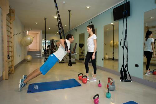 a man and a woman standing in a gym with shoes at Hotel Tropis in Tropea