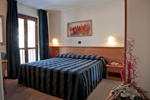 Habitación de hotel con cama y espejo en Hotel Alpechiara, en Pré-Saint-Didier