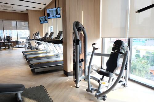 a gym with several treadmills and cardio machines at SKYVIEW Hotel Bangkok - Sukhumvit in Bangkok