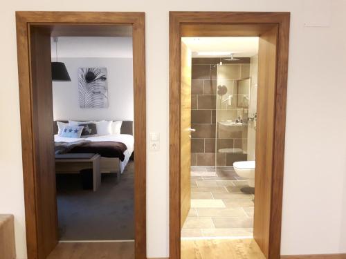 a bedroom with a bed and a bathroom at Alpen-Appartements Zürcher in Kappl