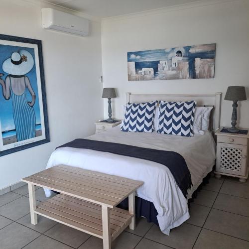 a bedroom with a bed and a wooden table at Hibberdene Beachfront Self-Catering 9 Catalina Bay in Hibberdene
