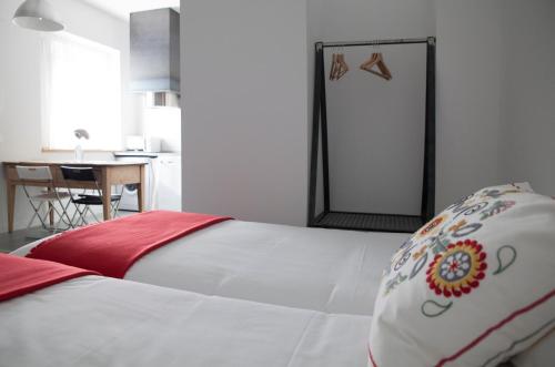 a bedroom with a white bed with a red pillow at Casa la Devesa de Sanabria in Remesal