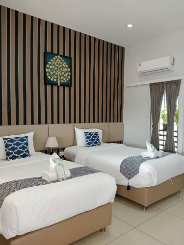 a hotel room with two beds and a tree picture on the wall at Chiang Mai Waroros Boutique Hotel in Chiang Mai