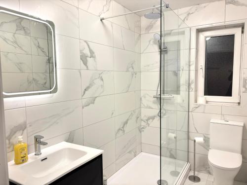 a white bathroom with a sink and a shower at The Seafarers Rest in Cobh