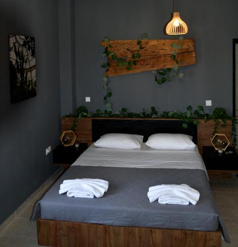 a bedroom with a bed with two white towels at Αλώνι - Aloni in Angathiás