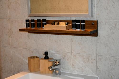 a bathroom sink with a mirror and a shelf above it at Αλώνι - Aloni in Angathiás
