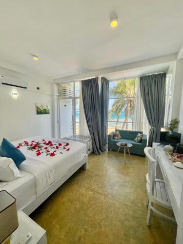 a bedroom with a bed with red roses on it at Baia Dikwella in Batigama