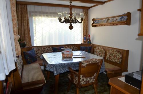 a dining room with a table and chairs and a chandelier at Ferienwohnungen Angermaier in Flattach