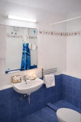 a blue and white bathroom with a sink and a toilet at Emma's HOUSE near beach in Tsakaíoi