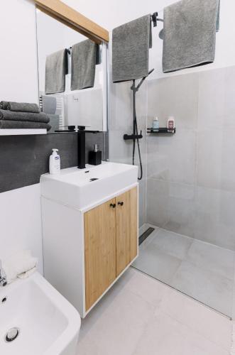 a white bathroom with a sink and a mirror at Larco Trieste studio living 3 in Trieste