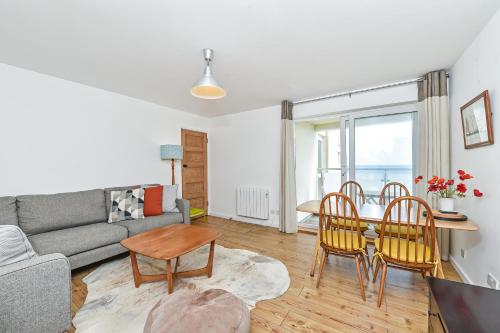 a living room with a couch and a table and chairs at Beach View - East Wittering in Chichester