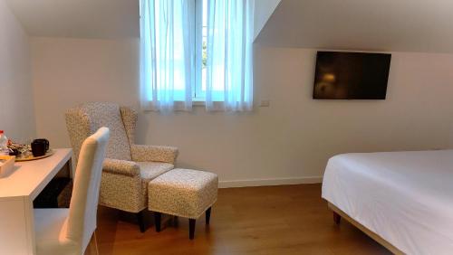 a bedroom with a bed and two chairs and a table at SantAgata bed&breakfast in Como
