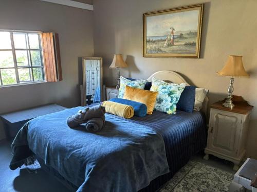 a bedroom with a bed with a blue comforter at Ouma Bettie Guesthouse in Piketberg
