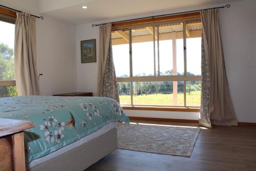 a bedroom with a bed and a large window at Montville House on the Hill in Montville