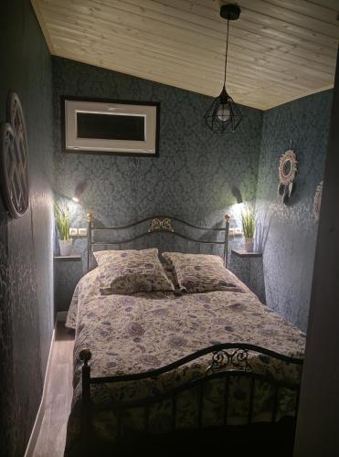 a bedroom with a bed with blue walls at Mise au vert in Saint-Juvin