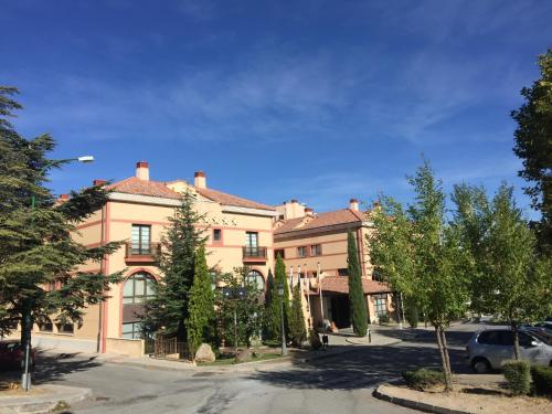 a large building with a car parked in front of it at Segovia Sierra de Guadarrama in Los Ángeles de San Rafael