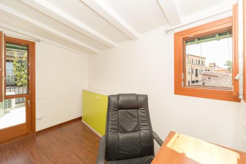 a room with a chair and a desk and a window at Venice Altanina Apartment in Venice