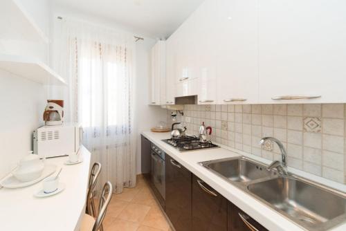 cocina blanca con fregadero y encimera en Venice Altanina Apartment, en Venecia