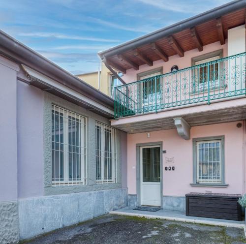 a pink house with a balcony and a door at Scuderia il Costa in Paratico