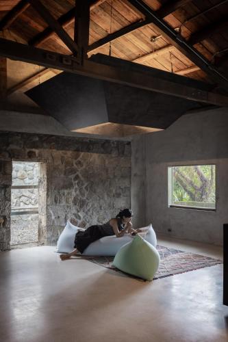 a woman laying on a bed in a room at 九份金光閃閃 Jiufen Glimmer Homestay in Jiufen