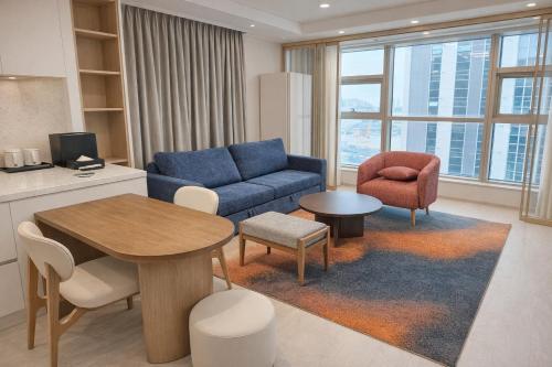 a living room with a blue couch and a table at Matie Busan Harbor City in Busan