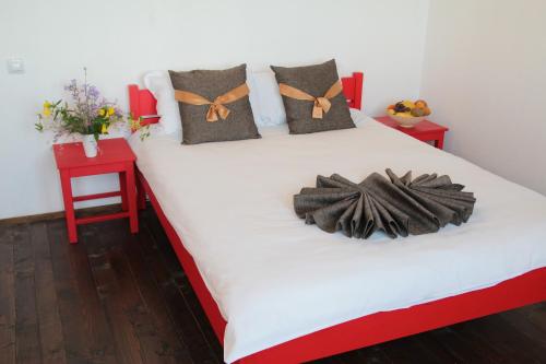 a bed in a room with two red tables at Арт комплекс Горски дом - Трявна in Tryavna