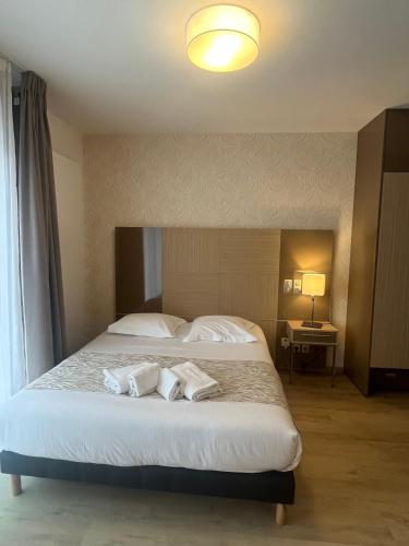 a bedroom with a large bed with two white pillows at Appart One Uzès in Uzès