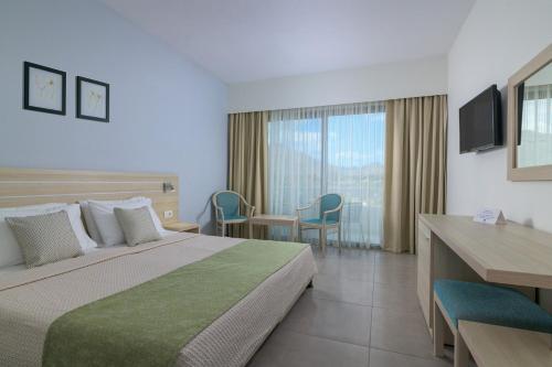 a hotel room with a bed and a desk at Niriides Hotel in Kolymbia
