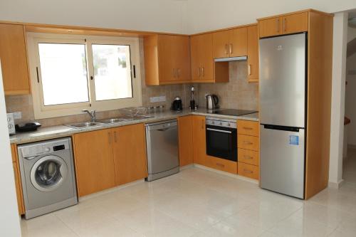 een keuken met een koelkast en een vaatwasser bij Anthorina Villa 19 in Protaras