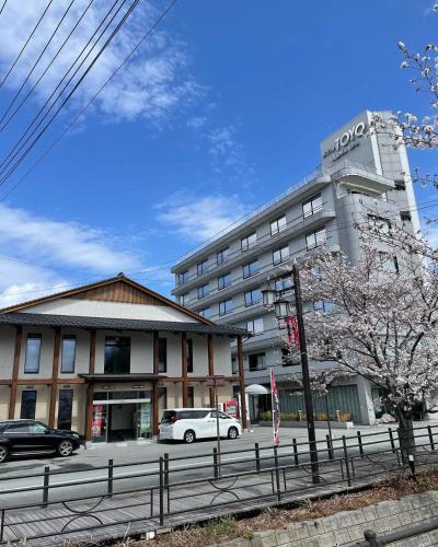 a white car parked in front of a building at 温泉ホテル東洋 in Fuefuki