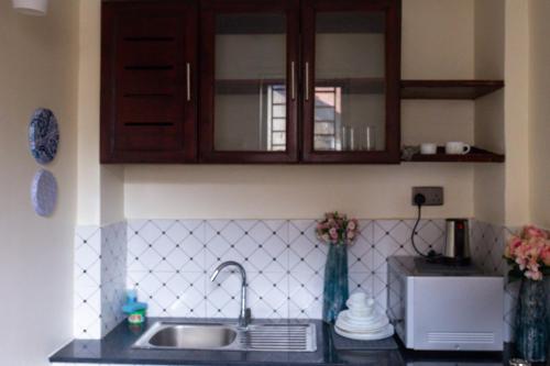 a kitchen counter with a sink and a microwave at Salasala Suites, Salasala, Mbezi Beach in Dar es Salaam