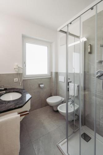 a bathroom with a toilet and a sink and a shower at Zeder Kraiterhof in Andrian