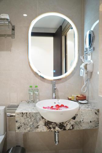 a bathroom with a white sink and a mirror at Blubiz Hotel 9 in Hanoi