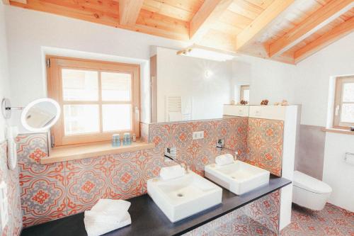 a bathroom with two sinks and a toilet at Luna Blanca Chalet in Schwangau